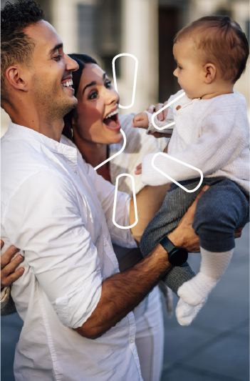 Pareja sosteniendo y sonriendo con su bebé